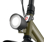 Close-up of a bicycle headlight attached to a bike frame with a white background